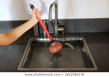 Сток-фото: Woman Cleaning Sink With Cup Plunger