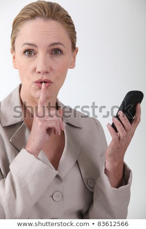 Stock fotó: Woman Indicating Quiet Whilst Holding A Phone