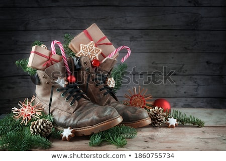 商業照片: Red Christmas Boot With Gifts On Background Wooden Wall