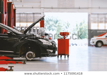 [[stock_photo]]: Mechanic Repairing Car On Hydraulic Lift