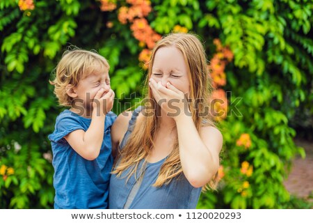 Stock foto: Mom And Son Sneeze In The Park Against The Background Of A Flowering Tree Allergy To Pollen Concept