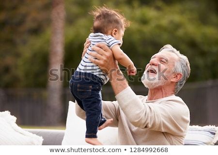 Stockfoto: Grandfather Sitting With Baby Grandson