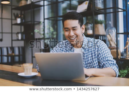 Stockfoto: Young Asian Man Working With Laptop In Cafe