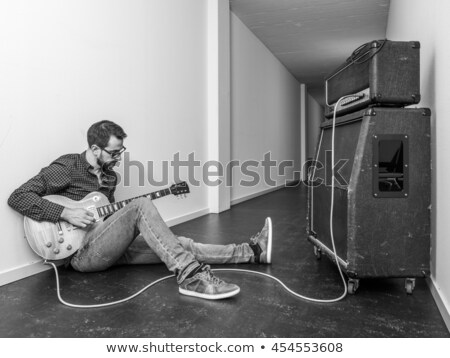 Foto stock: Man Playing An Electric Guitar In A Hallway
