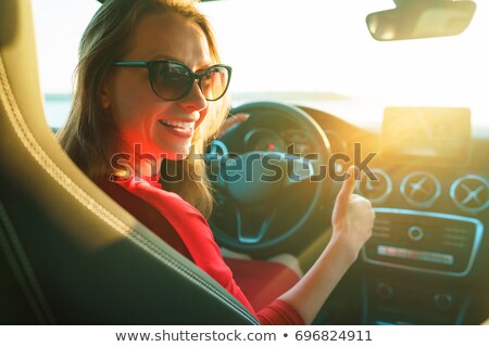 Stock fotó: Happy Woman In Red Dress With Thumb Up Sitting In Car