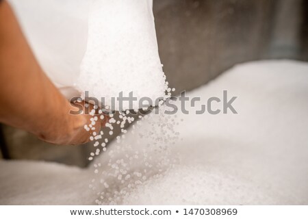 Small Plastic Granules Scattering Out Of White Sack Held By Worker Stockfoto © Pressmaster