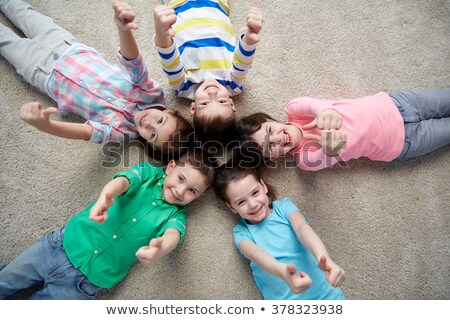 Stok fotoğraf: Happy Kids Lying On Floor And Showing Thumbs Up
