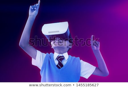 Stock photo: Schoolboy Wearing Virtual Reality Headset Enjoying With Arms Raised Against White Background