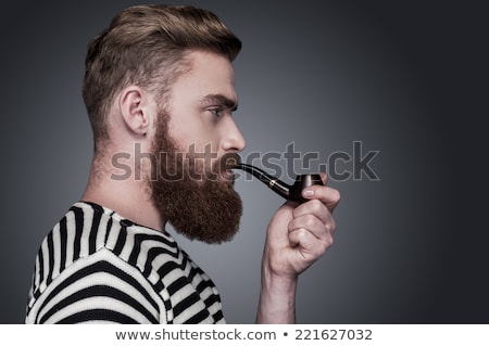 Foto stock: Fashion Man With Beard Smoking And Looking Away