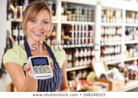 Stok fotoğraf: Sales Assistant In Food Store Handing Credit Card Machine To Cus