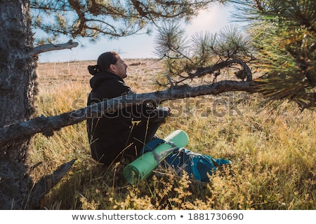 Foto stock: Young Caucasian Man With Backpack Sitting On The Top Of Hill