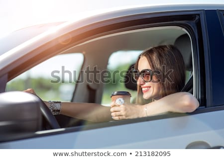 [[stock_photo]]: Woman With Coffee To Go Driving Her Car