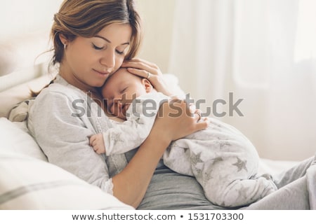 Сток-фото: Portrait Of A Beautiful Mother With Her 2 Month Old Baby In The Bedroom