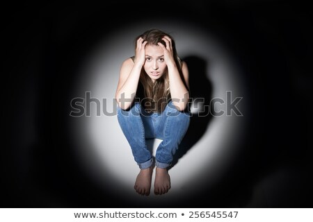 Stockfoto: Sad Woman Sitting In Pool Of Light