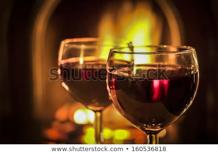 Foto d'archivio: Two Glasses Of Red Wine At A Cosy Fireplace