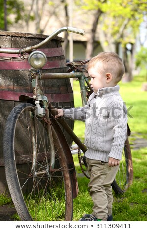 Foto stock: 2 Years Old Curious Baby Boy Walking Around The Old Bike