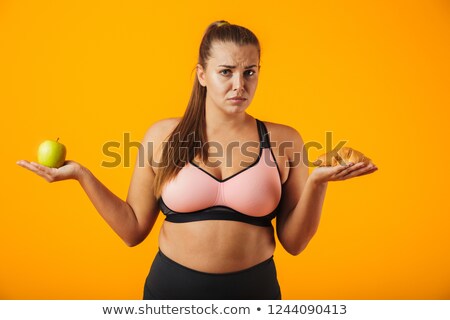 Stockfoto: Image Of Puzzled Chubby Woman In Tracksuit Holding Apple And Cro