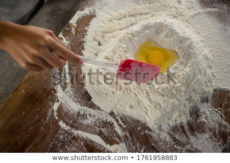 Foto d'archivio: Woman Mixing Flour And Egg With A Batter Spatula