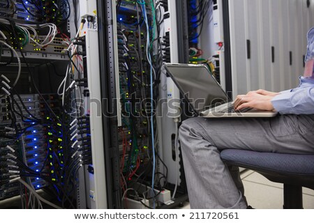 ストックフォト: Technician Sitting On Swivel Chair Using Laptop To Diagnose Serv