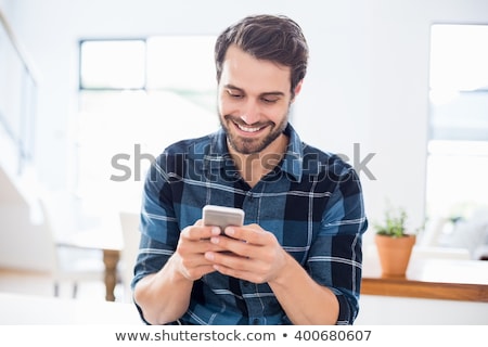 Foto stock: Young Man Using Mobile Phone Texting