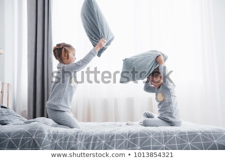 Foto d'archivio: Portrait Kids Fighting With Pillows In Bed