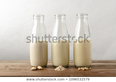 Stockfoto: Almond Milk In A Glass Bottle And Almond Nuts On A Stand