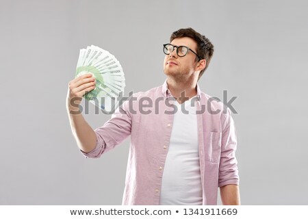 Foto stock: Happy Young Man In Glasses With Fan Of Euro Money