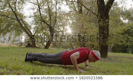 Сток-фото: Muscular Man Doing Push Ups In A Park