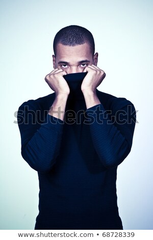 Foto d'archivio: Young Hiding African American Man In Black Sweater Isolated On White Background