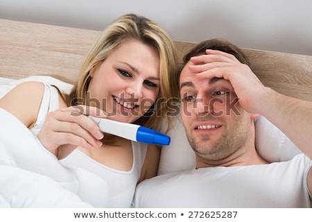 Stock fotó: Happy Couple Looking At Pregnancy Test On Bed In Bedroom