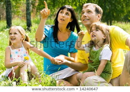 Stock fotó: Young Woman Showing Something To Her Husband And Daughter