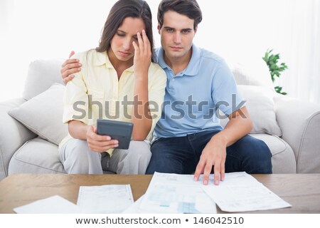 Сток-фото: Fearful Couple Doing Their Accounts Sat On A Couch