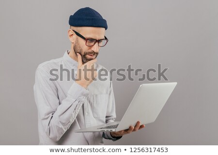 Сток-фото: Attentive Student Holds Chin Focused In Monitor Of Laptop Computer Searches Information For Projec