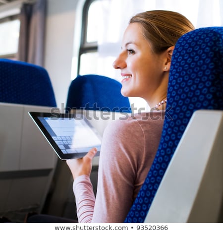 商業照片: Young Woman Using Her Tablet Computer While Traveling By Train