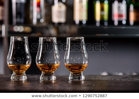 [[stock_photo]]: Outeilles · vides · et · verre · de · brandy · sur · fond · sombre