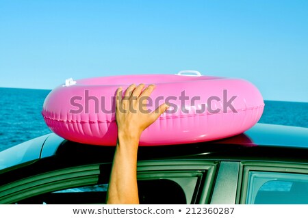 Man Holding A Swim Ring Outside Of The Window Of A Car Foto stock © nito