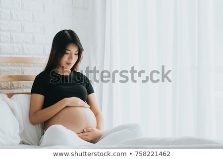 Сток-фото: Happy Pregnant Asian Woman Sitting In Bed At Home