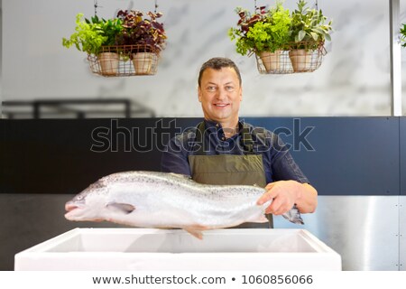 Stock fotó: Happy Male Seller Holding Trout At Fish Shop