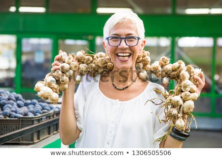 [[stock_photo]]: Senior Woman Buying Lot Of Garlic On Market