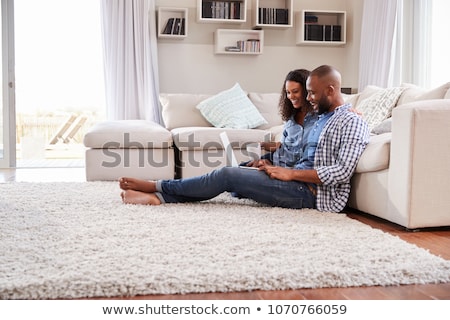 Foto stock: Smiling Woman With Pillow Sitting And Using Laptop At Home