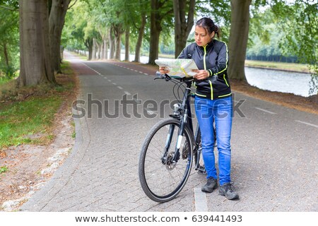 [[stock_photo]]: Woman With Mountainbike Reading Road Map On Street