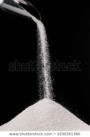 Foto stock: Sugar Falling From Metal Scoop On Pile Isolated On Black