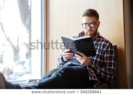 Stock foto: Young Man Reading Book In Library