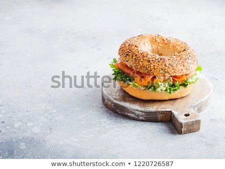 ストックフォト: Fresh Healthy Bagel Sandwich With Salmon Ricotta And Lettuce On Black Plate On Black Kitchen Table