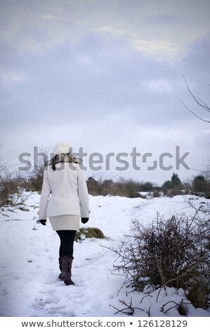 Foto d'archivio: Girl In Warm Clothes In Winter Walking On Snow Covered Snowdrifts