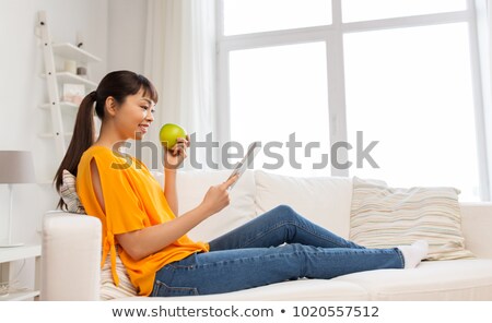 Stok fotoğraf: Happy Asian Woman With Tablet Pc And Apple At Home