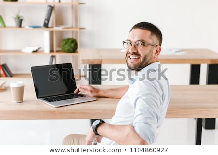 Stockfoto: Half Turn Photo Of Pleased Office Man 30s In White Shirt Sitting