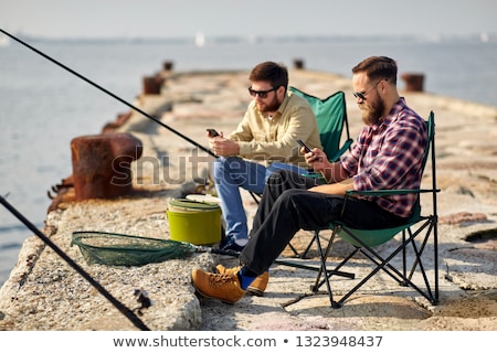 Stock photo: Friends With Smartphones Fishing On Pier At Sea