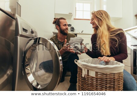Foto stock: Man Putting Clothes Into The Washing Machine