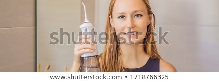 Stock foto: Woman Using An Oral Irrigator In Bathroom Banner Long Format